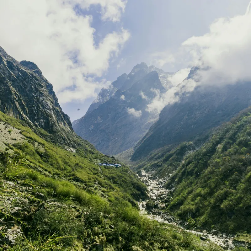 Deep green Modi Khola valley with high mountain peaks shrouded in clouds along the Annapurna trek route.