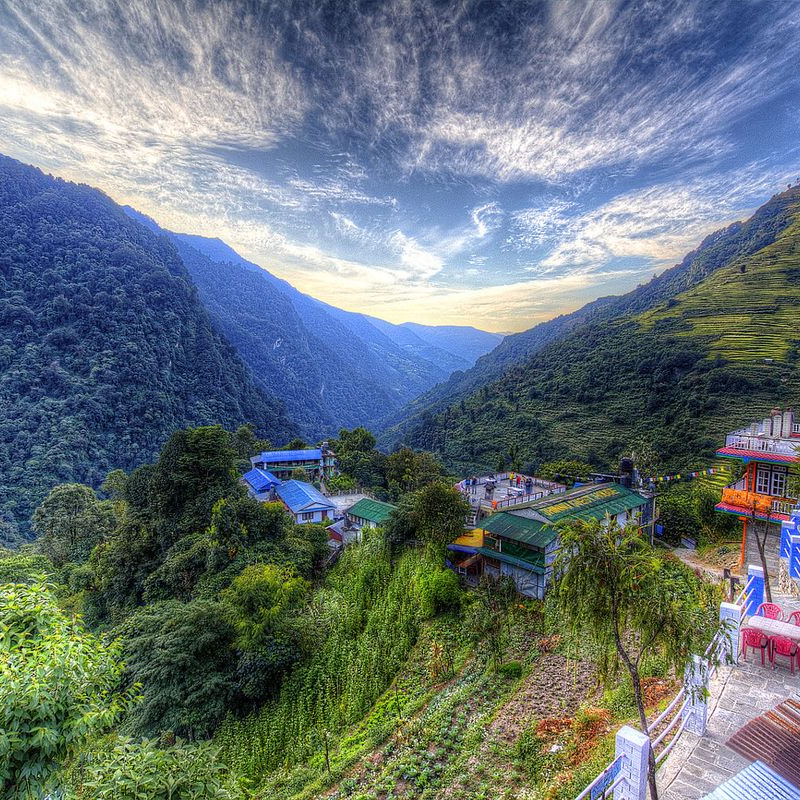 Colorful guest houses and hillside lodges in Jhinu Danda overlooking deep green mountain valleys on the Ghorepani Poon Hill trekking route Nepal.